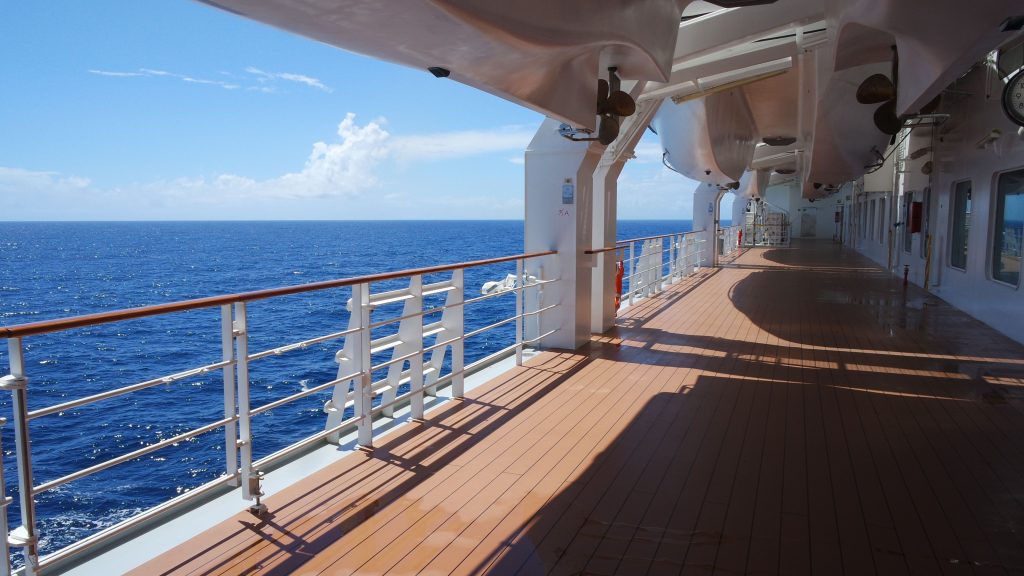 Large cruise ship docked at a tropical Caribbean island port during a sunny vacation day.
