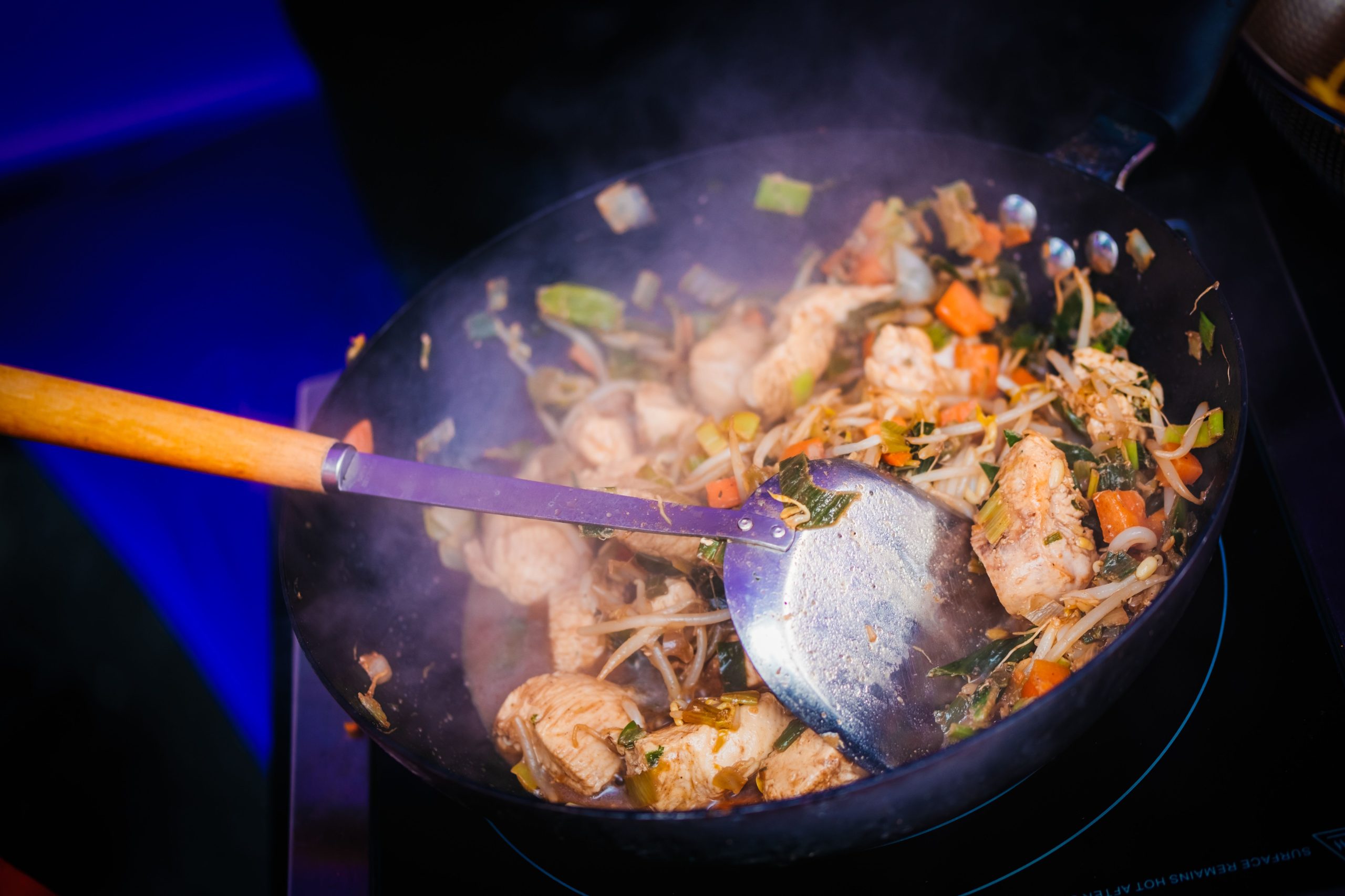cooking hot pad thai over high heat wok in bangkok