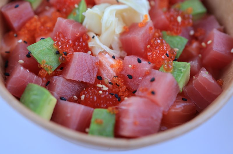 A fresh traditional Hawaiian poké bowl at a beachside setup.