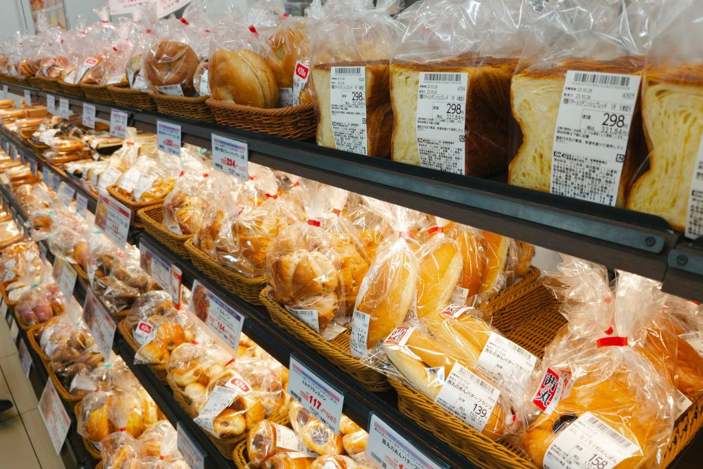 Shopper reading ingredient labels in the US supermarket dairy aisle to find authentic Mexican cheese