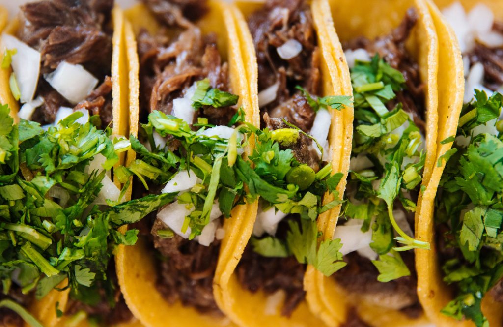 Close up of fresh mexican al pastor tacos on a grill with zero people