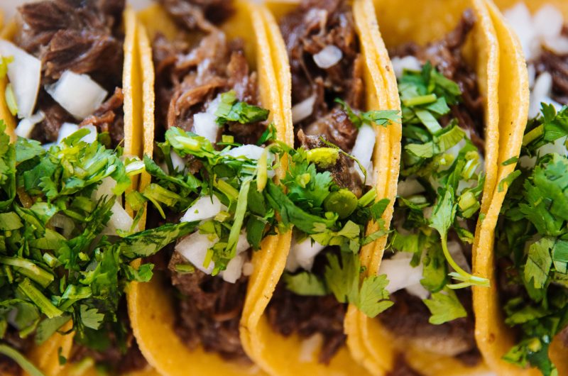 Close up of fresh mexican al pastor tacos on a grill with zero people