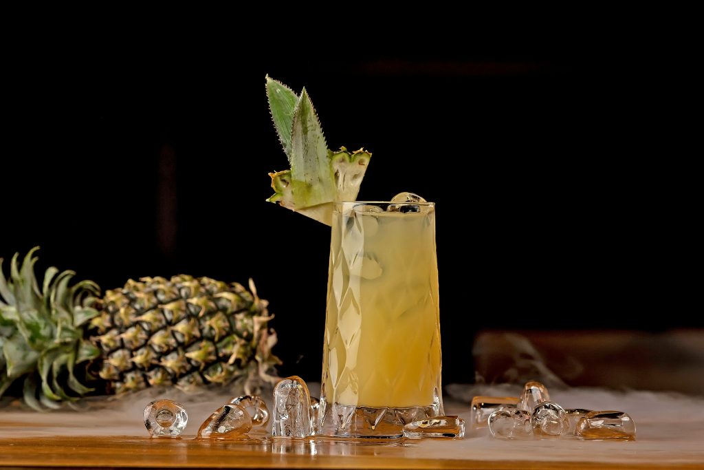 A refreshing tropical cocktail glass filled with ice cubes on a resort bar counter in the Dominican Republic.